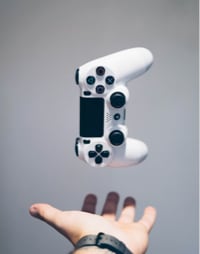 image of a ps4 controller floating over someones hand